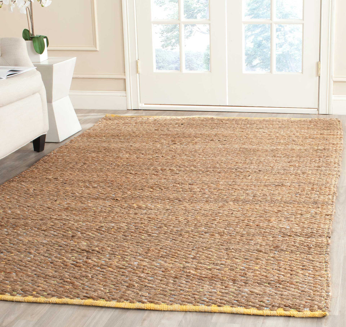 Golden jute rug brings quiet warmth beneath furniture, with yellow edge trim