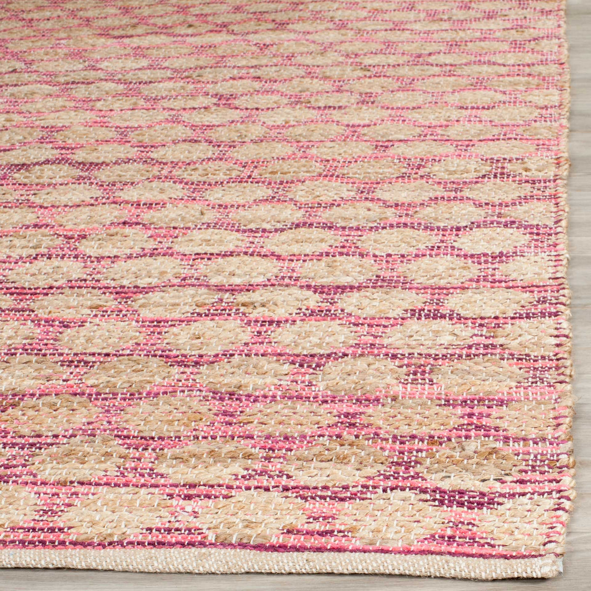 Rose-maroon threads frame tan jute loops above a tightly woven edge