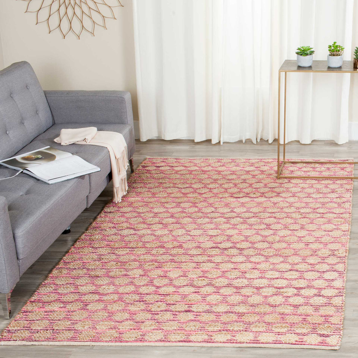 Maroon geometric accents warm a natural woven rug beneath a sofa