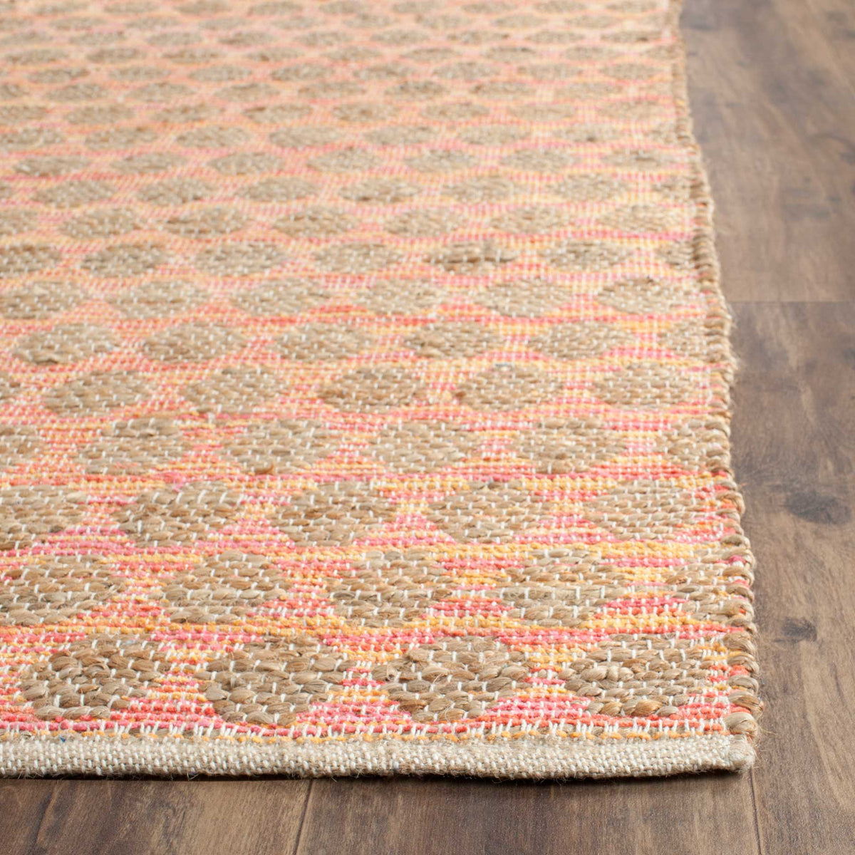Orange woven outlines surround tan jute loops beside a tidy rug edge