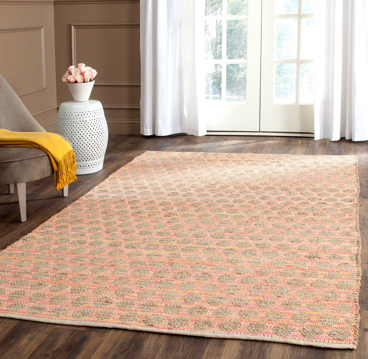 Warm coral-orange accents brighten a natural rug with subtle rounded motifs