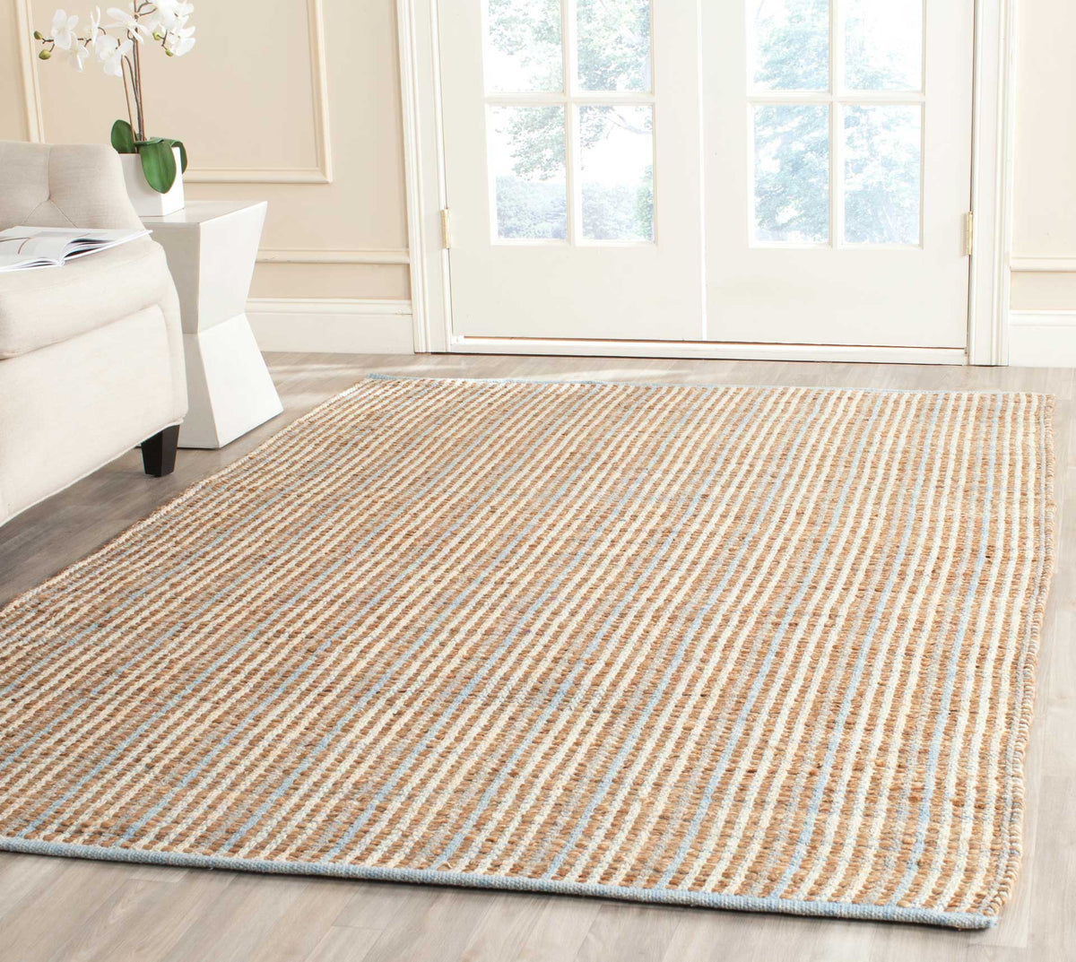 Natural striped jute rug adds an airy, finely textured base beneath seating