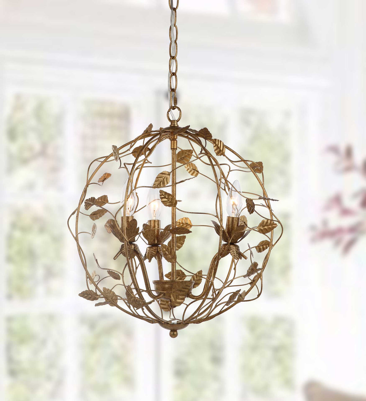 Three glowing bulbs shine through a graceful globe of gold branches and leaves.