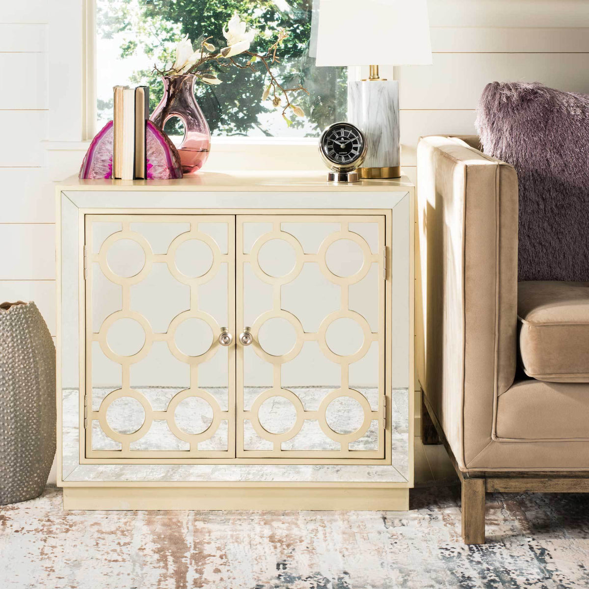 Mirrored circle-pattern doors bring a glamorous shimmer to an antique beige chest
