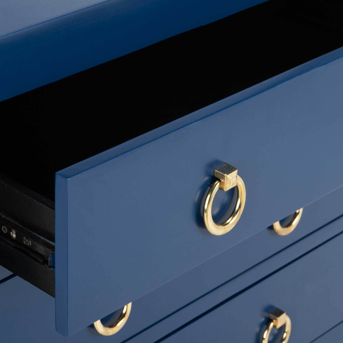 Lapis blue drawer opens to a dark interior, accented by a gold ring pull