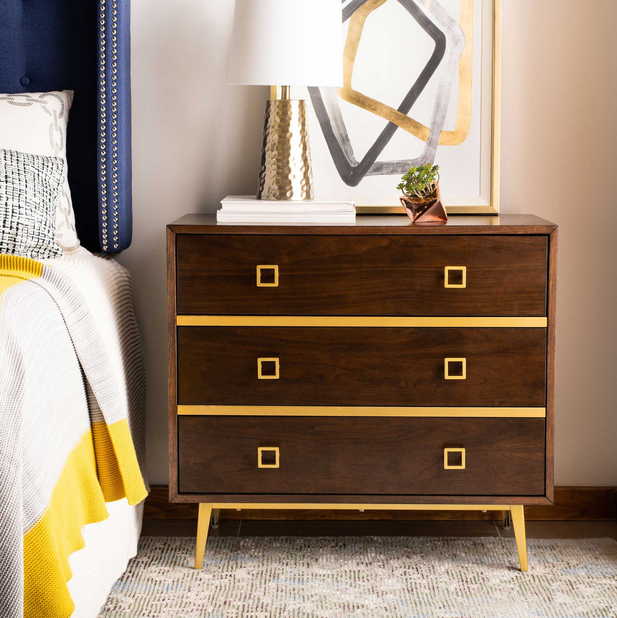 Warm walnut drawers with gold trim and tapered legs anchor a stylish bedside space.
