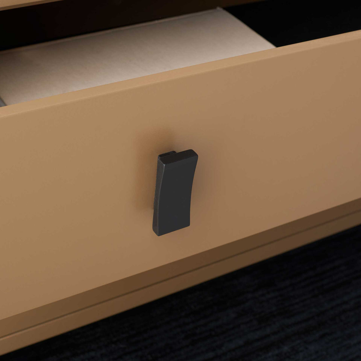 A substantial black pull adds contrast to the smooth taupe drawer front