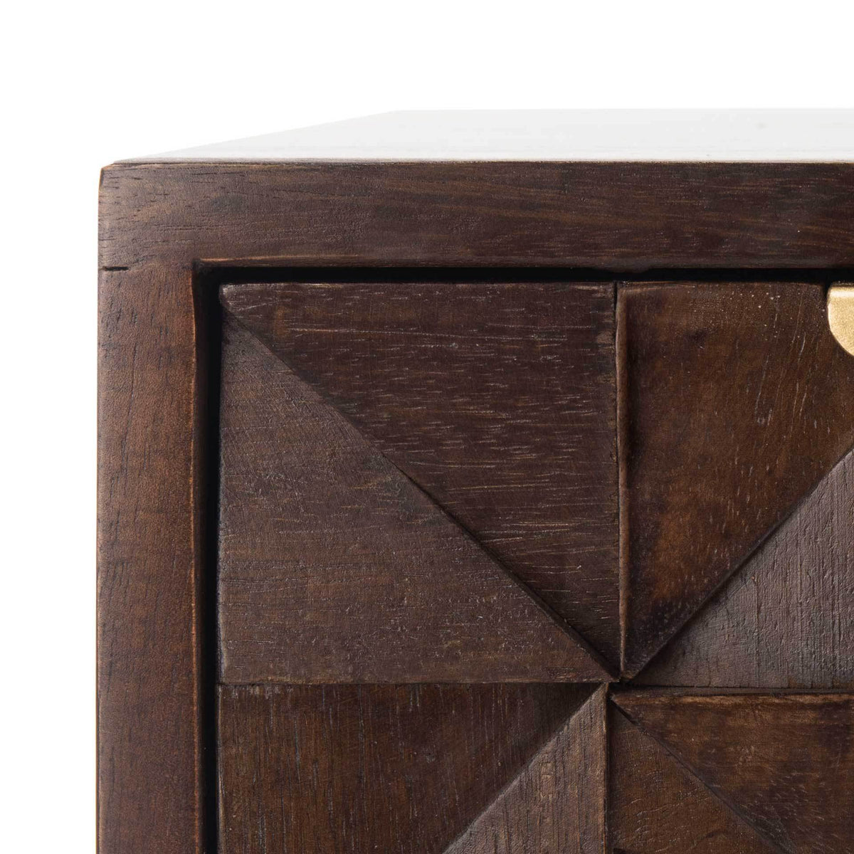 Angular wood carvings give the walnut drawer fronts a bold, dimensional pattern.