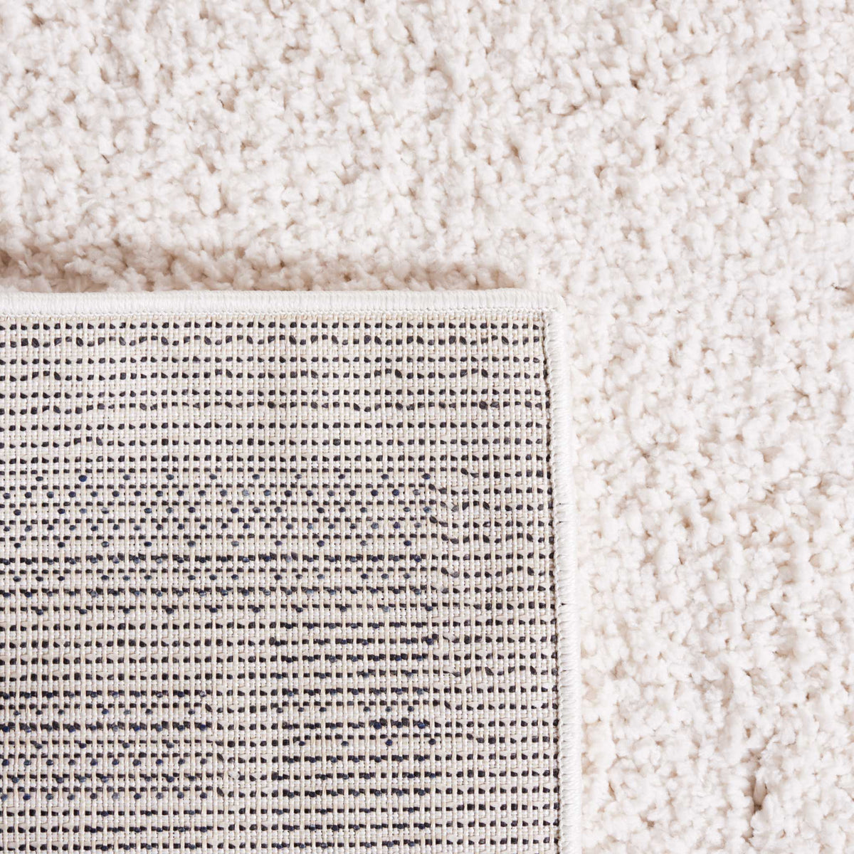 Tightly woven backing contrasts with the fluffy ivory shag surface