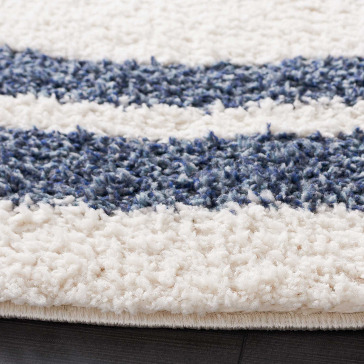 Dense ivory and blue shag pile creates soft contrast along the finished edge