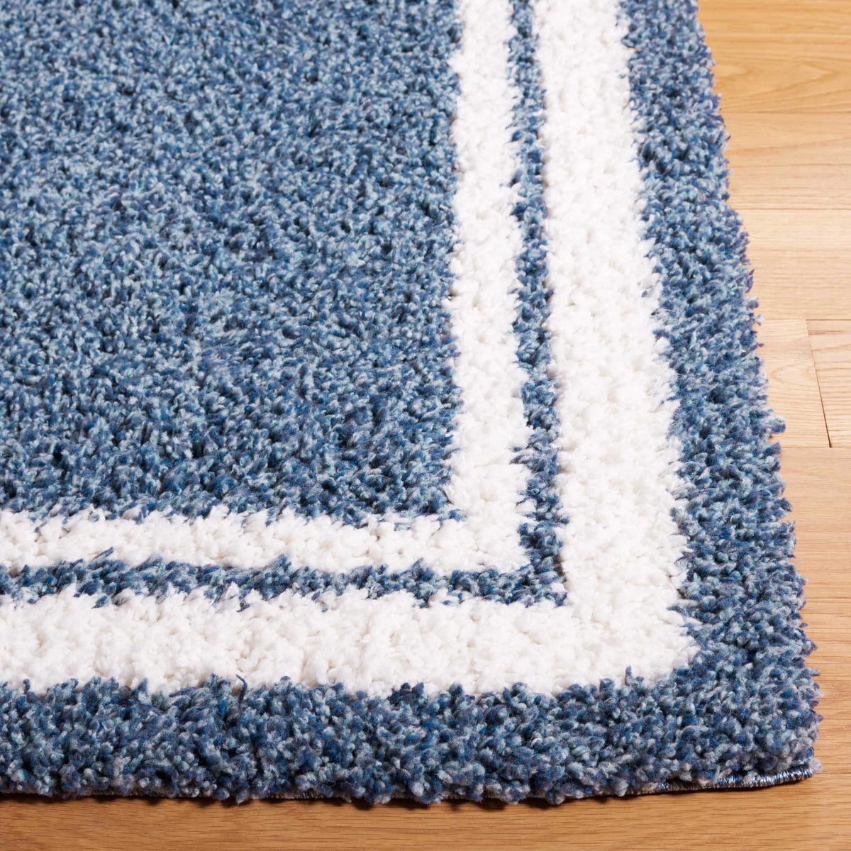 Thick blue shag meets bold ivory stripes along a neatly finished edge
