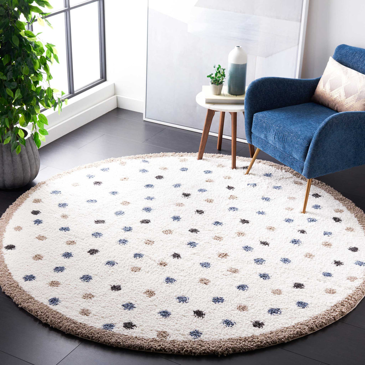 Multicolored dots add a playful touch to an ivory round rug beside a blue armchair