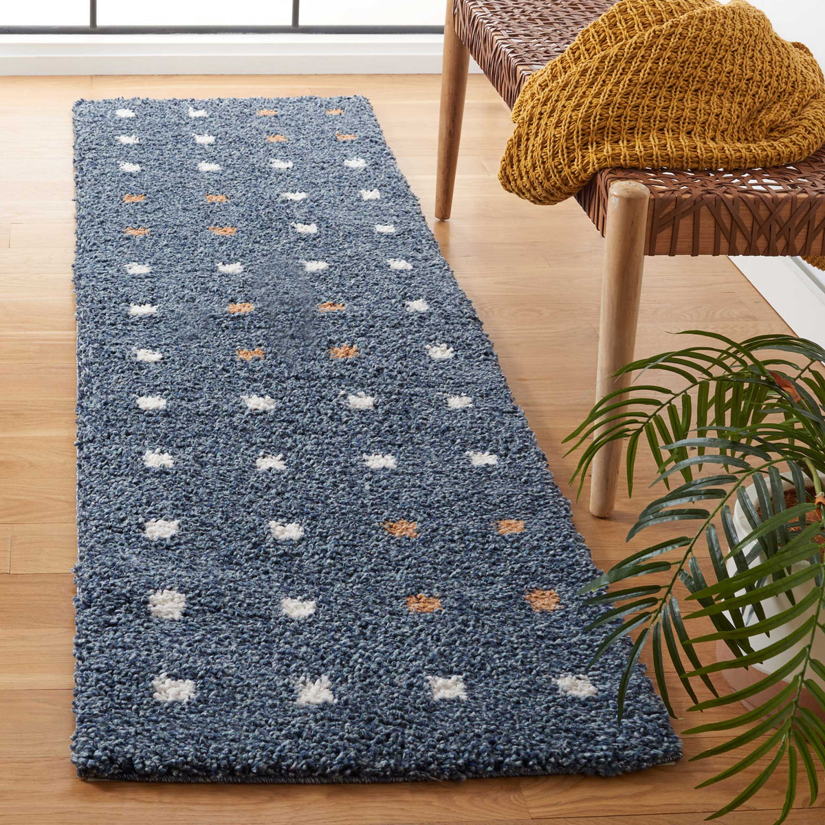 Deep blue shag pile dotted with raised ivory and orange accents looks playful and plush.