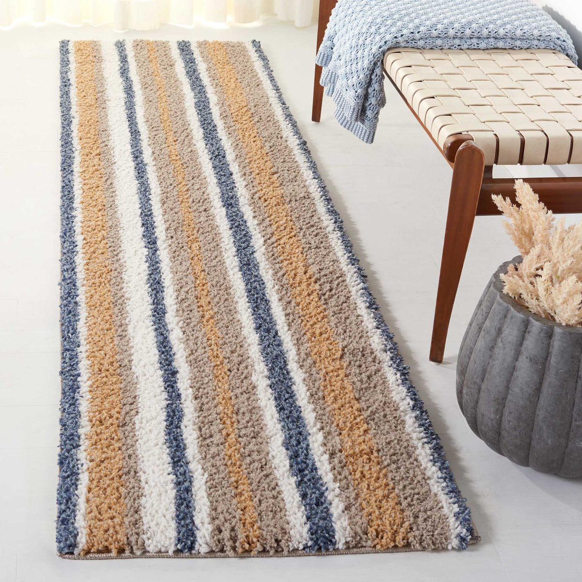 Wide taupe and ivory shag bands mingle with narrow blue stripes for a warm, textured look.
