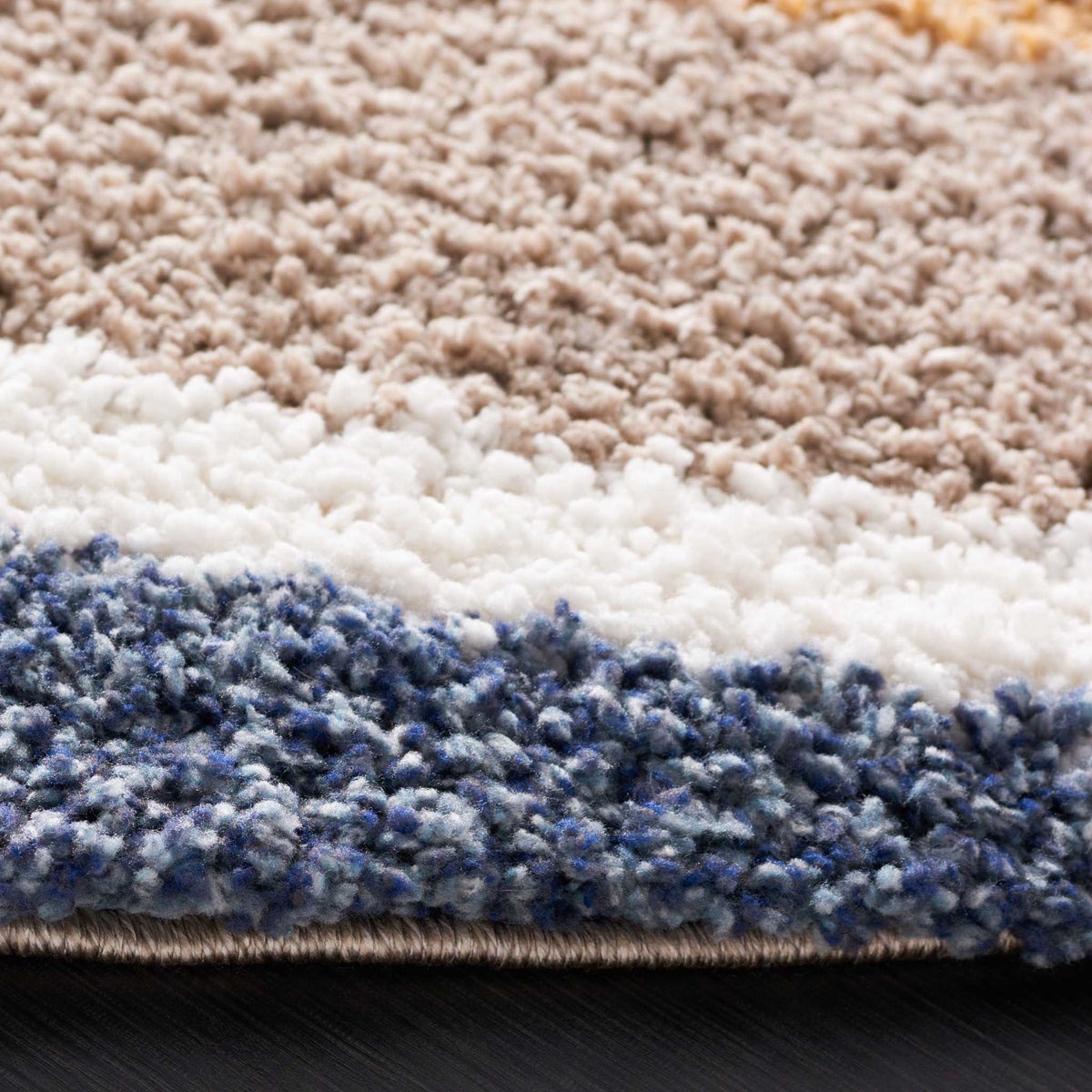 Plush taupe, ivory, and blue bands reveal thick shag and a finished edge