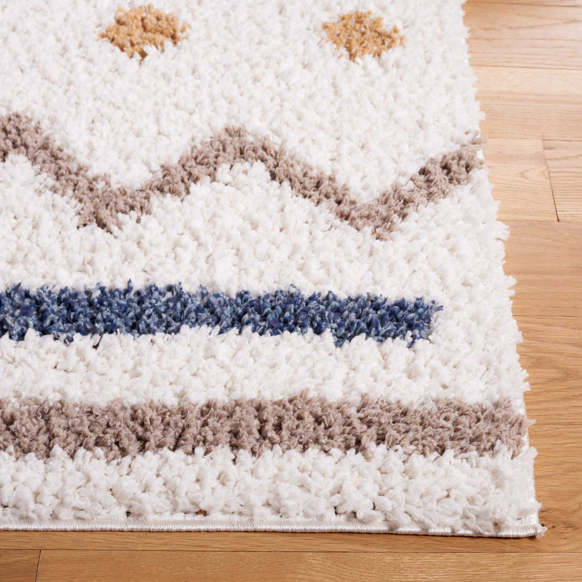 Taupe zigzags and blue lines add contrast to a plush ivory edge