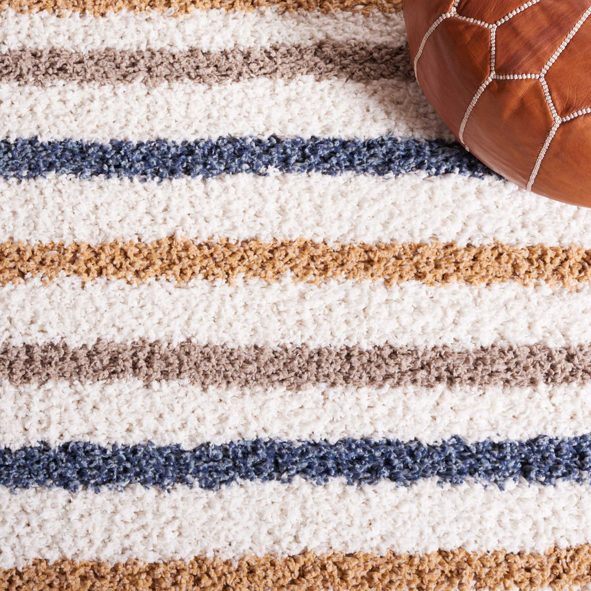 Rows of blue, gold, and taupe dashes add rhythm to soft ivory shag