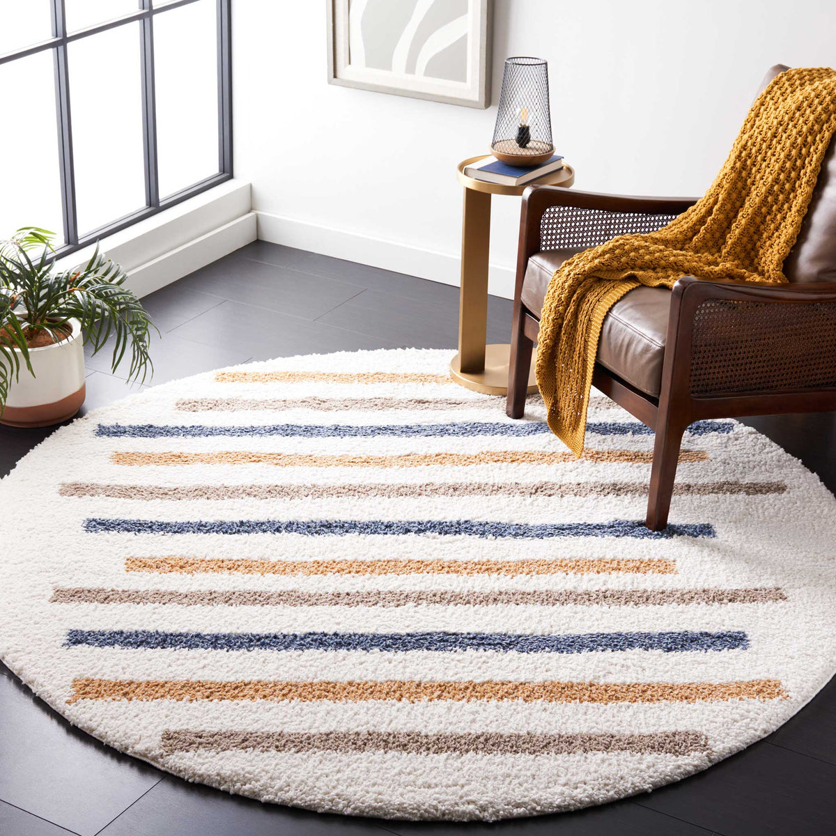 Slim multicolored stripes bring warmth and balance to a plush ivory round rug