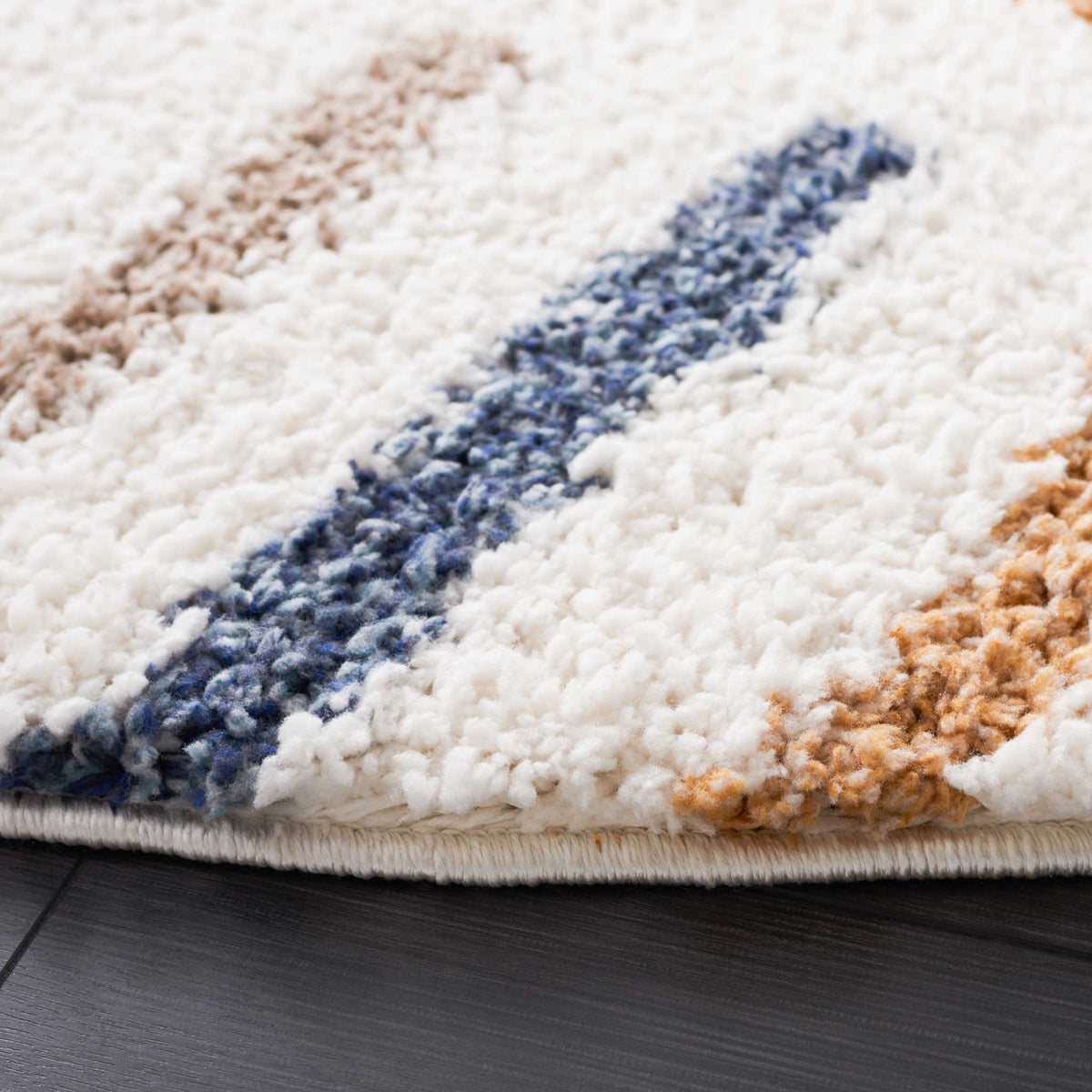 Soft ivory pile surrounds textured blue, taupe, and golden accents at the finished edge