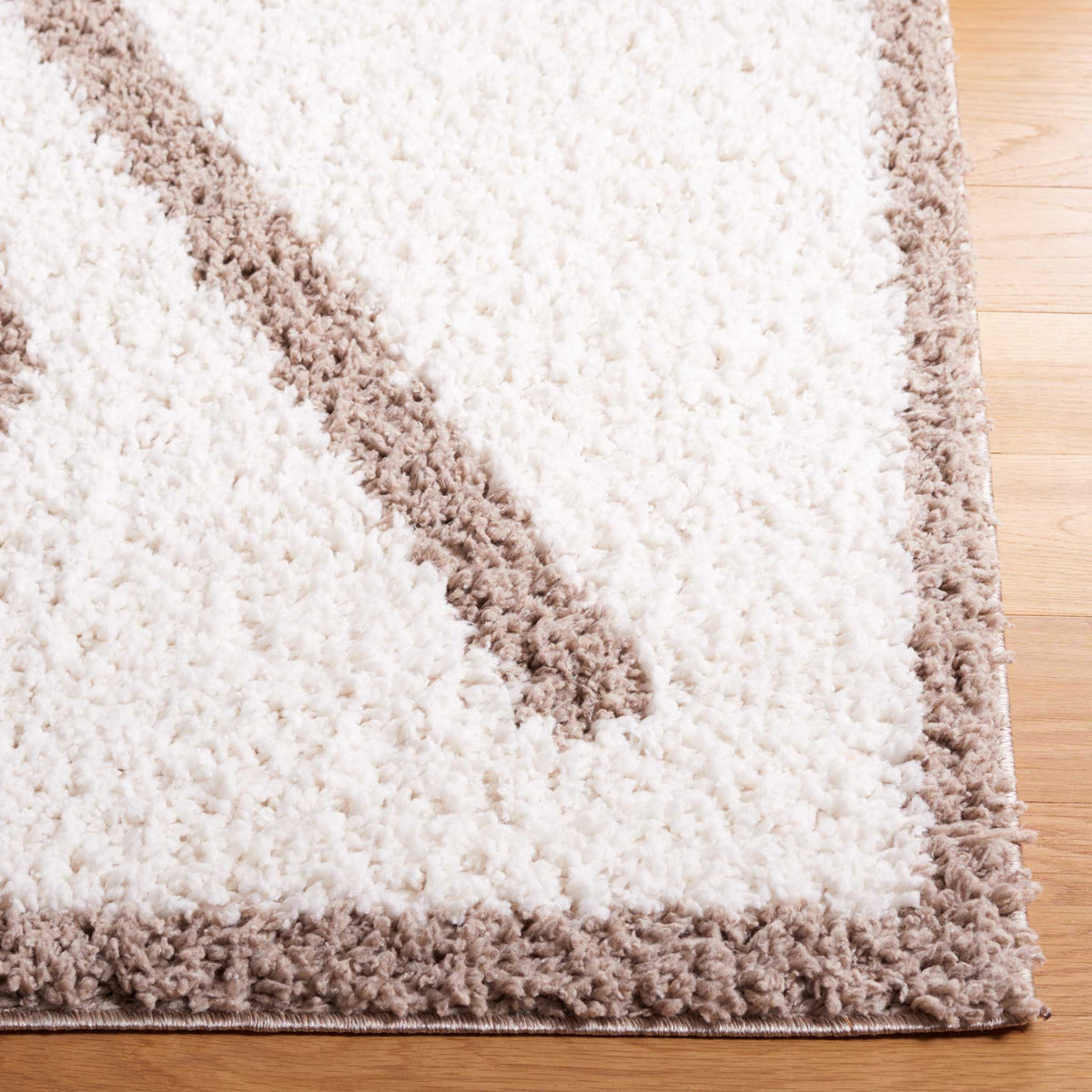 A taupe diagonal and border frame the soft ivory shag surface