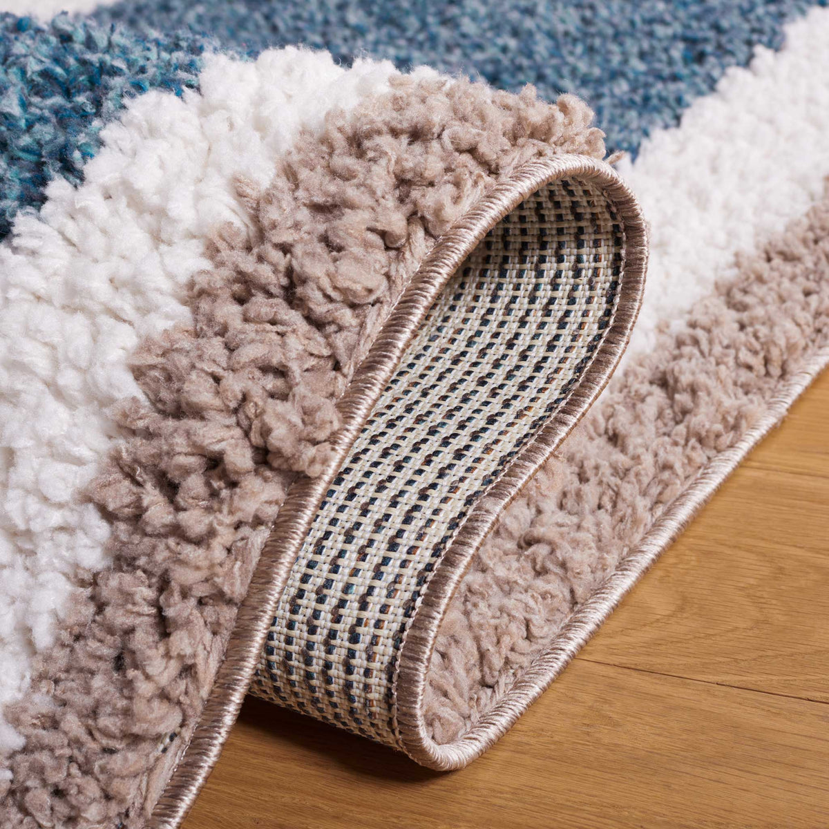 Folded taupe and ivory pile exposes the rug's woven underside
