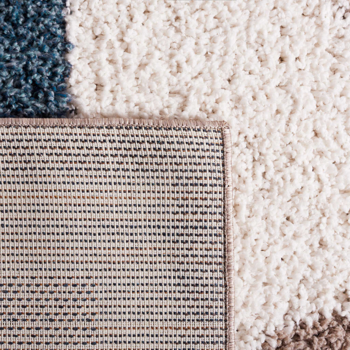 Tightly woven backing contrasts with the plush ivory and blue pile