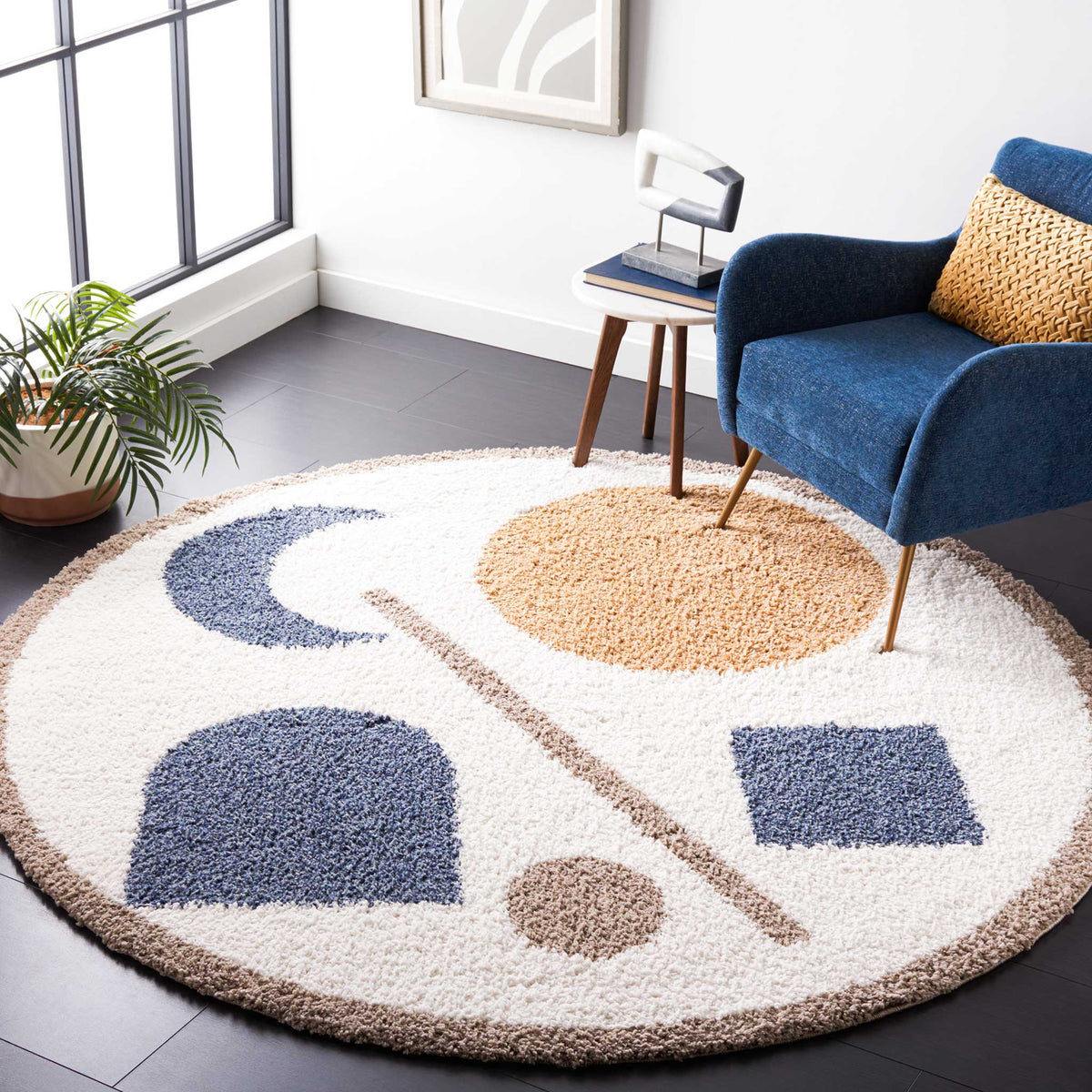 Golden and blue shapes stand out against an ivory round rug beside a blue chair