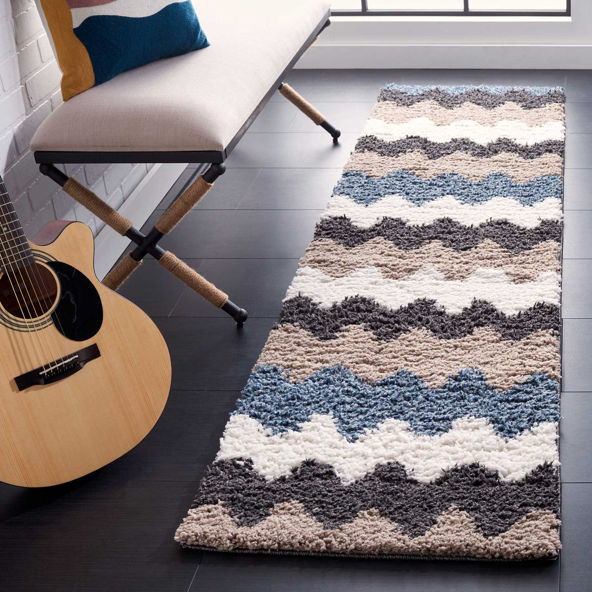 Dense shag pile gives the black, blue, taupe, and ivory zigzag bands a bold look.