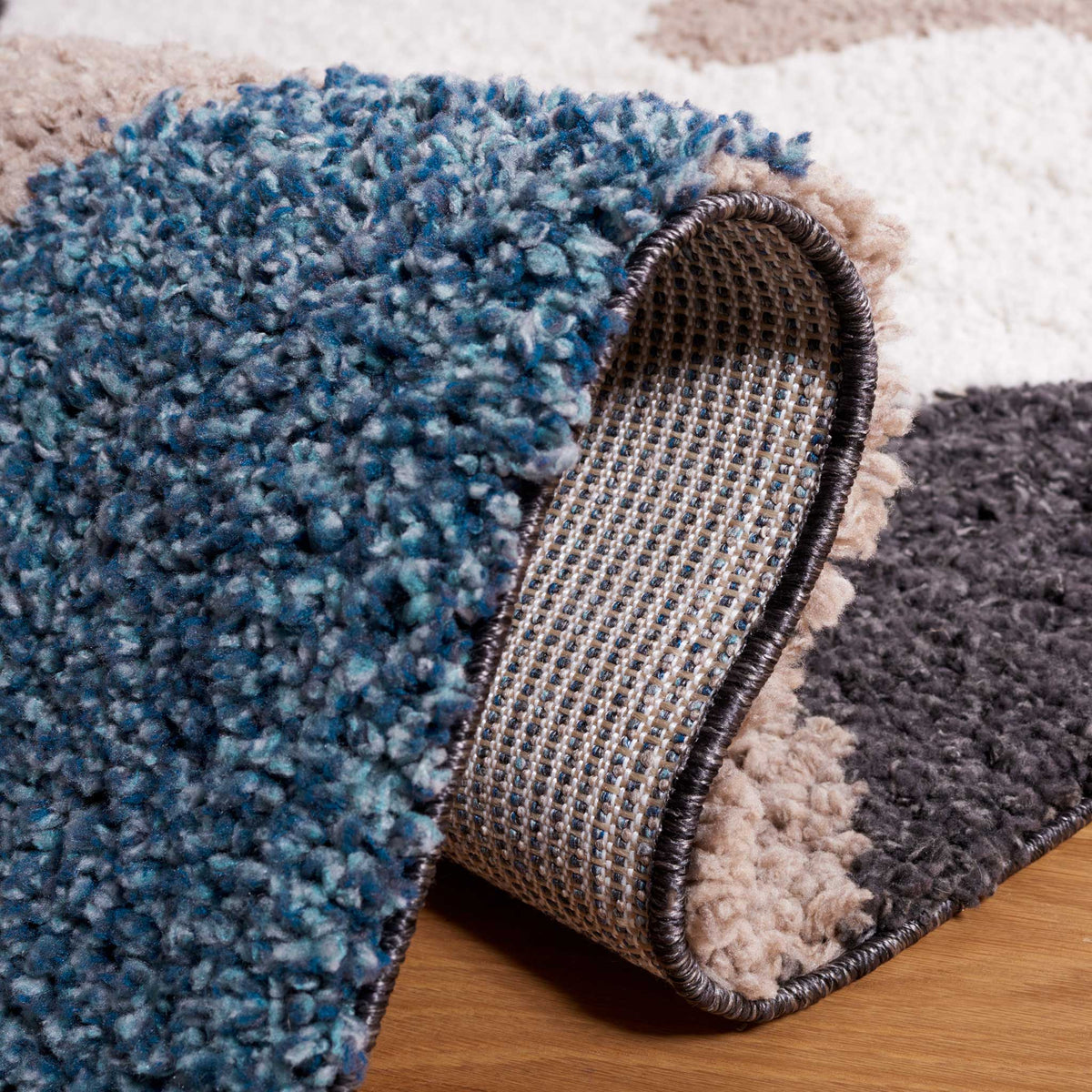 A folded blue shag edge reveals woven backing beneath the wavy design