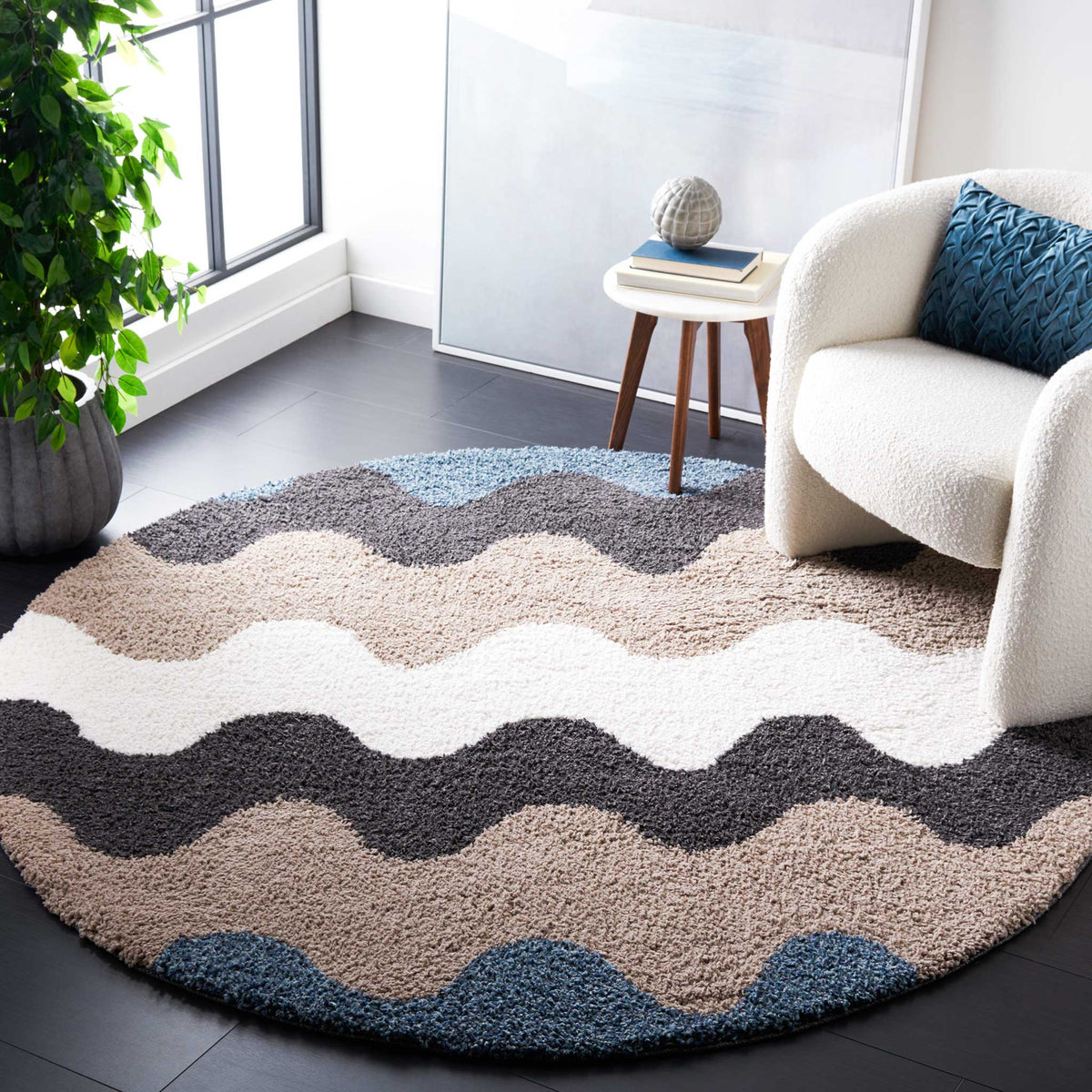 Broad black and taupe waves frame an ivory band on a plush round rug
