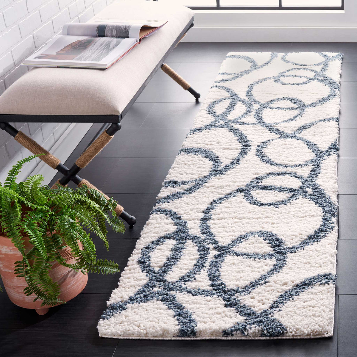 Thick ivory pile sets off interlacing blue circular lines for a playful, flowing pattern.