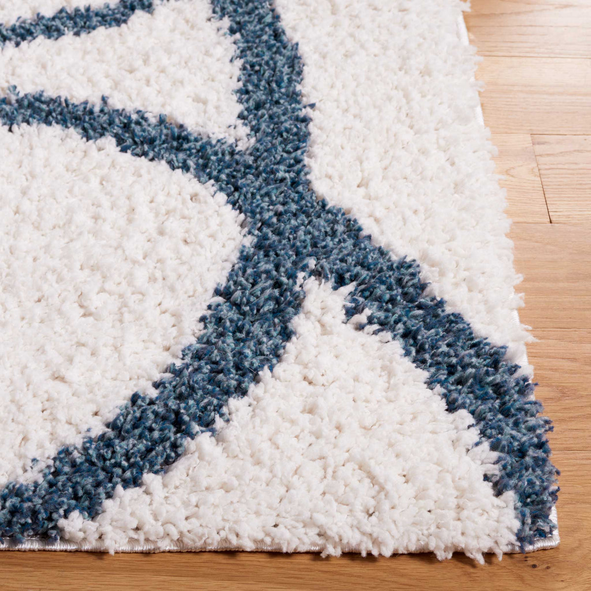 Bold blue curves cross a fluffy ivory field near its finished edge