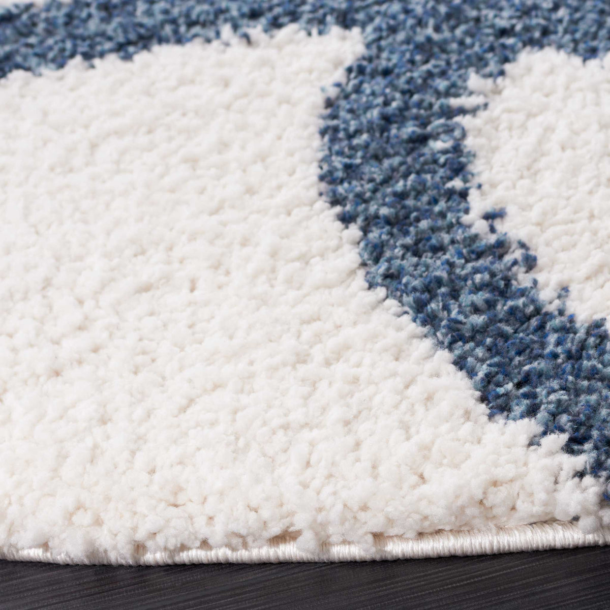 Thick ivory shag meets a deep blue curved line along a finished edge