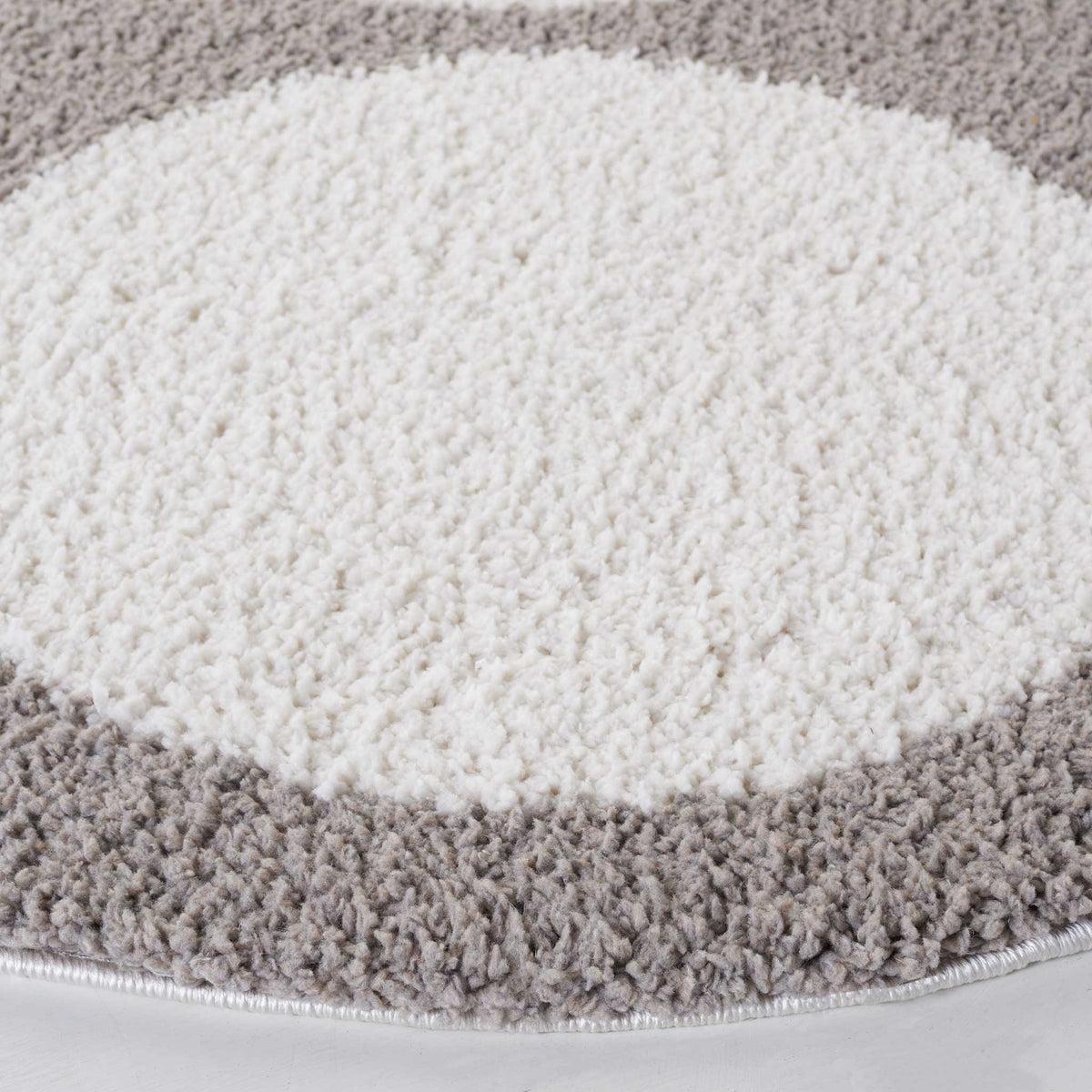 Soft ivory circle stands out against gray shag and a neatly trimmed edge