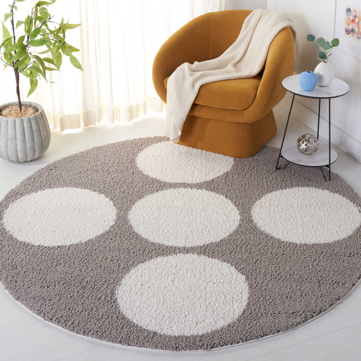 Large ivory dots soften a gray round rug beneath a warm-toned lounge chair