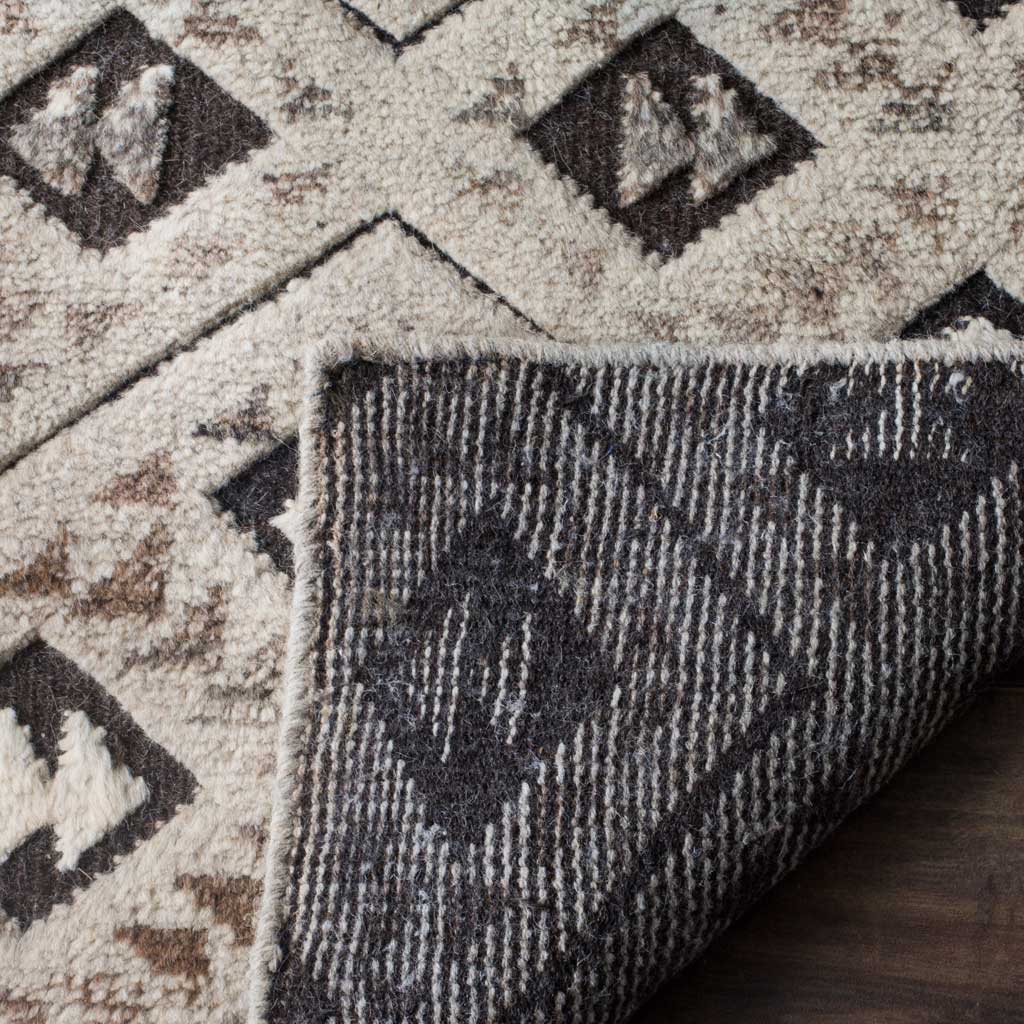 A turned-back corner reveals woven backing beneath the patterned wool pile