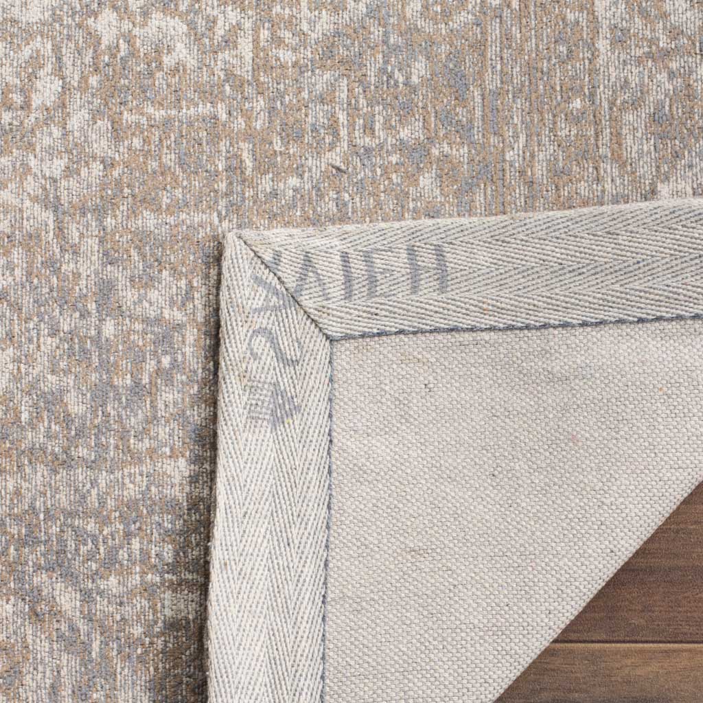 A light woven backing and stitched border complement the rug's muted beige floral face.
