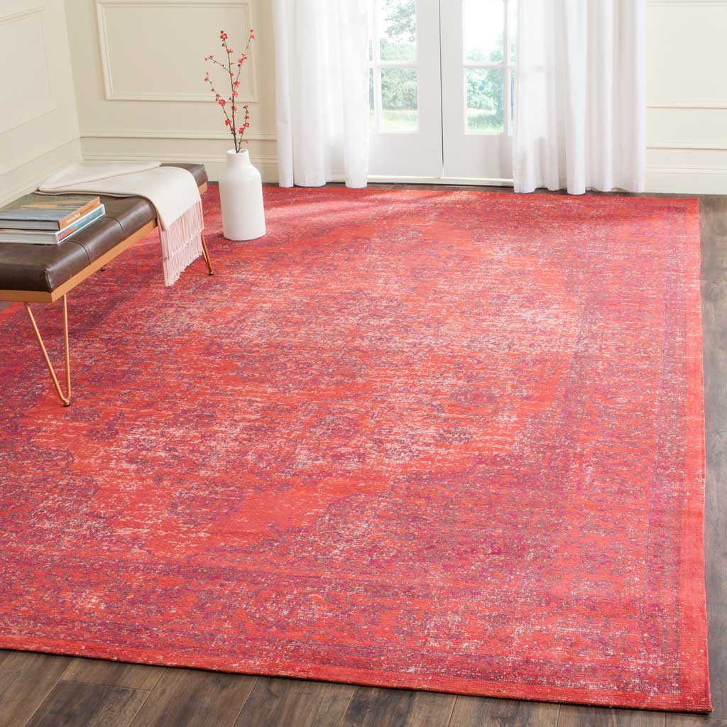 Warm red and orange hues fill the room with the rug's weathered ornamental pattern.