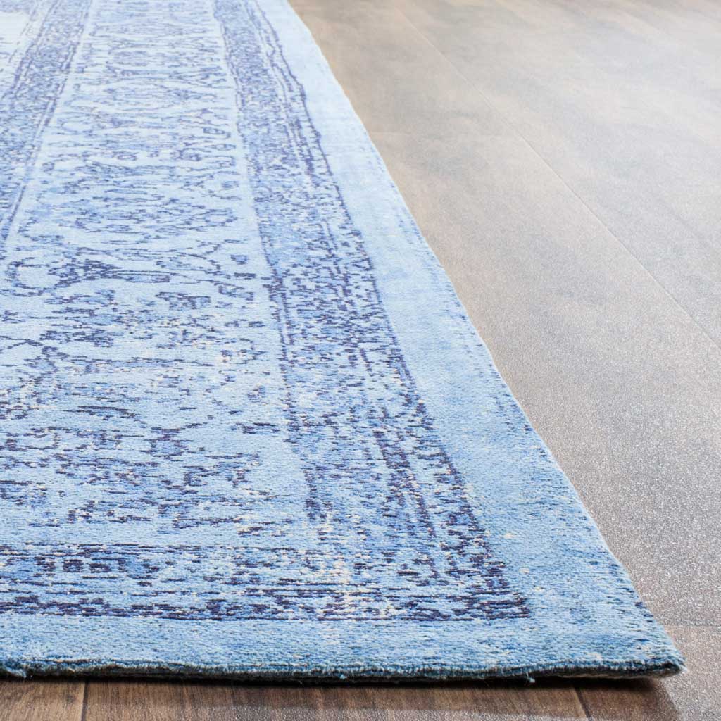 Weathered blue motifs and a tidy woven edge add texture along the rug's border.