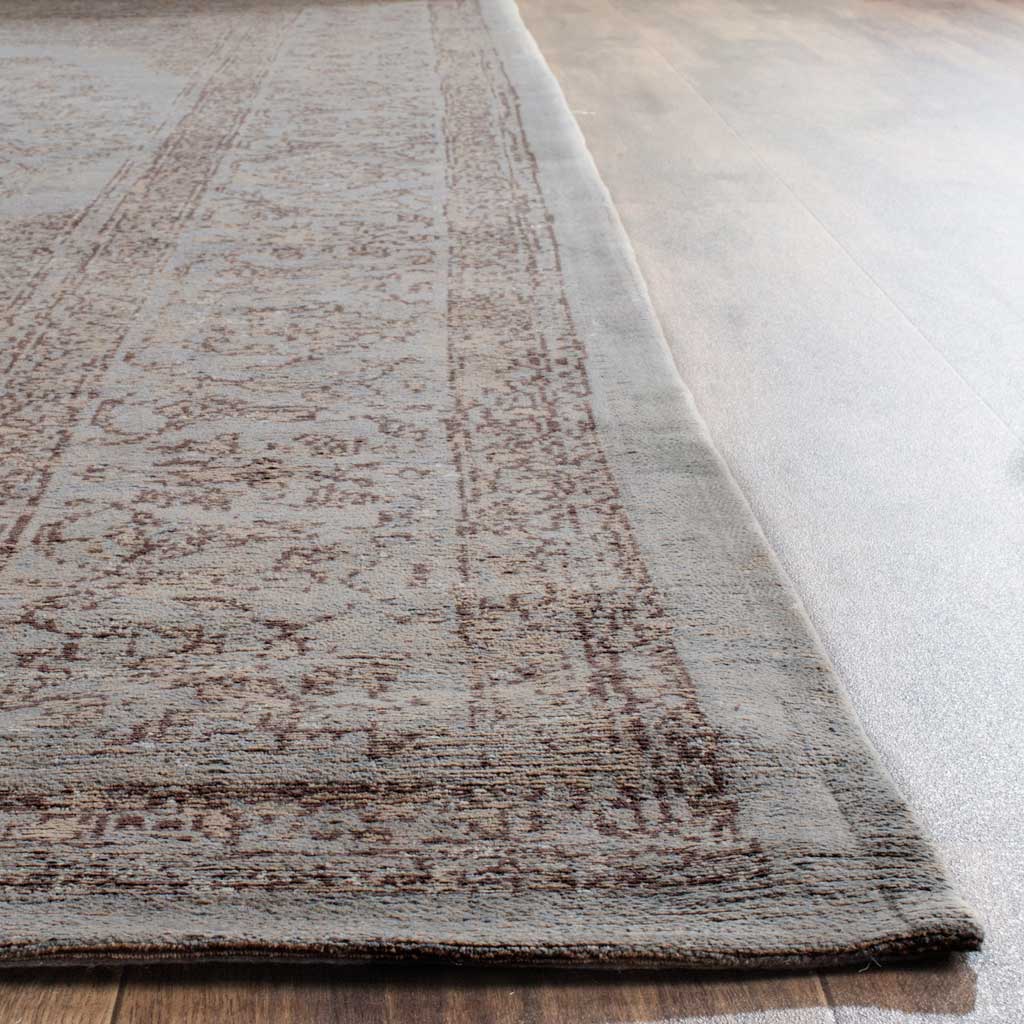 Subtle gray scrollwork and a narrow finished edge highlight the rug's low texture.
