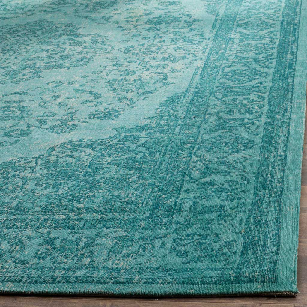 Fine aqua scrollwork and a slim bound edge highlight the rug's traditional detailing.