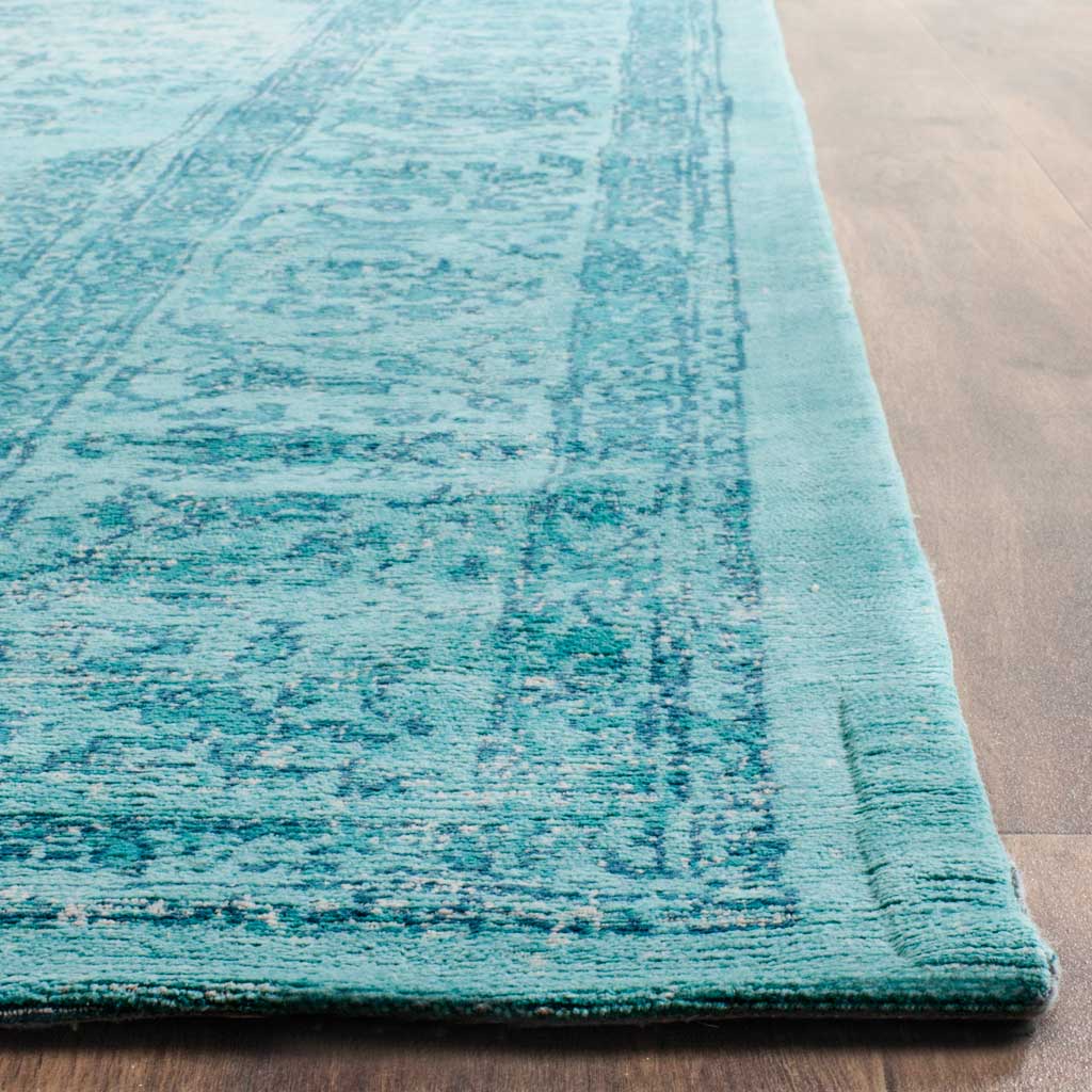 Turquoise fibers reveal a softly faded floral border and a clean, finished edge.