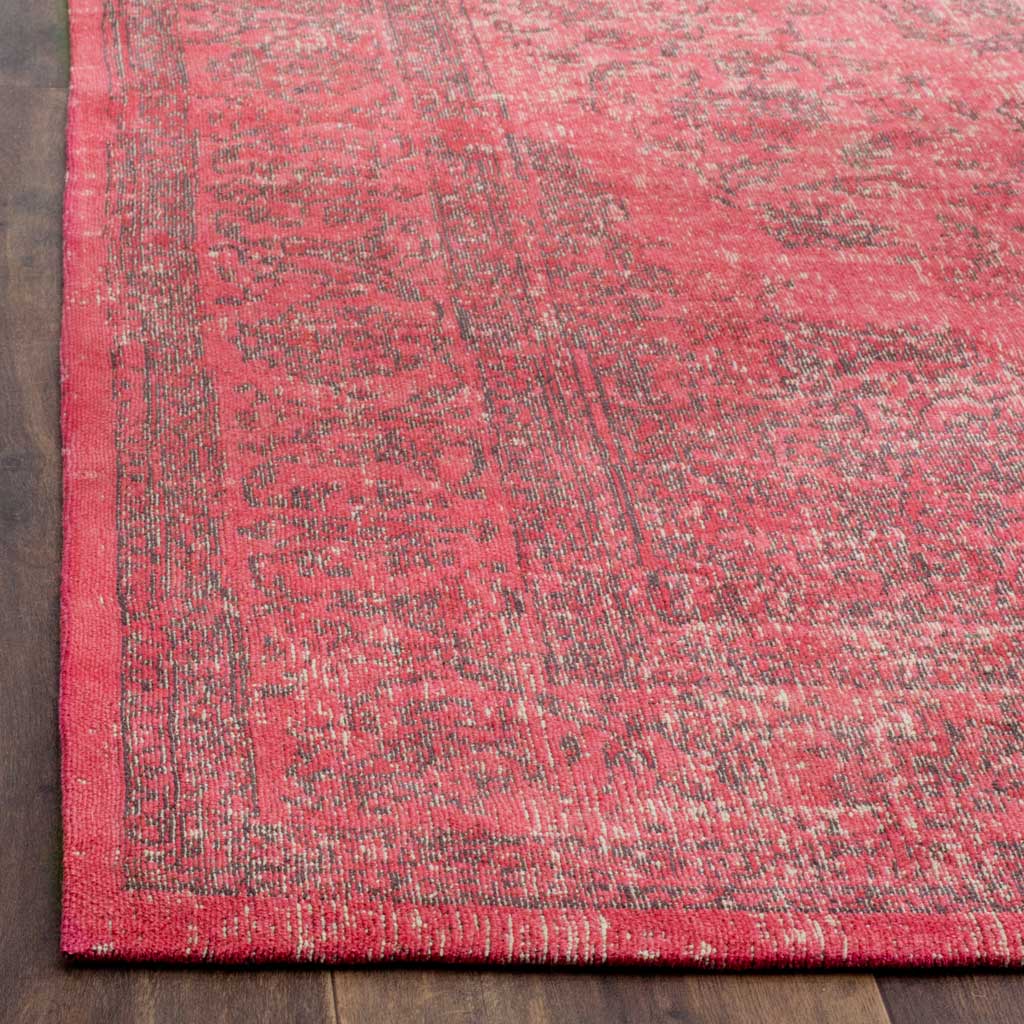 Fuchsia fibers and faded charcoal detailing meet at the rug's softly finished corner.