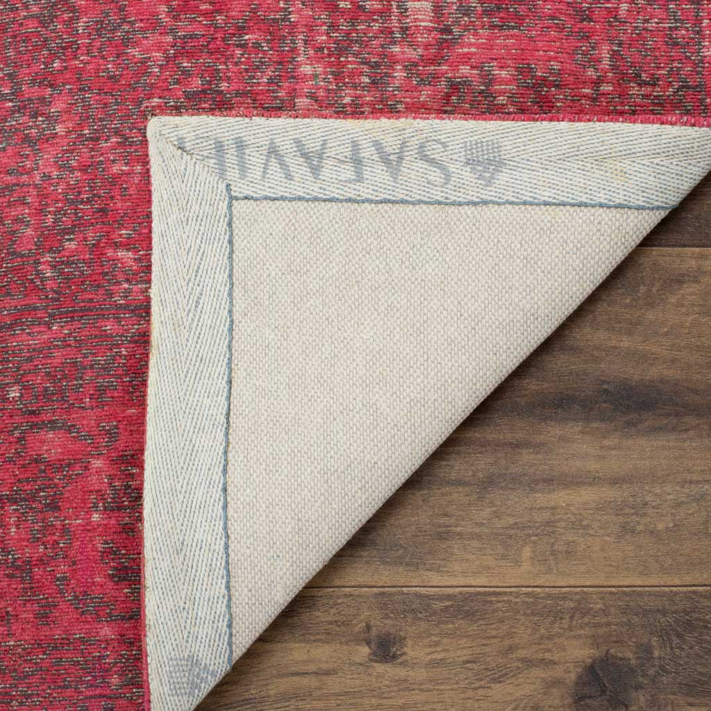 A pale woven underside and bound edge finish this vivid pink patterned area rug.