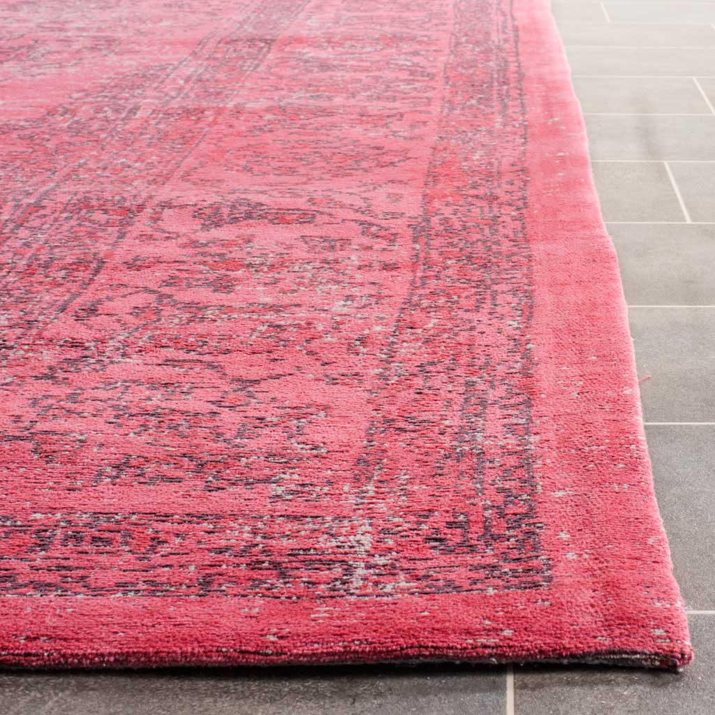 A neatly finished edge reveals the rug's vivid pink pile and dark distressed border.