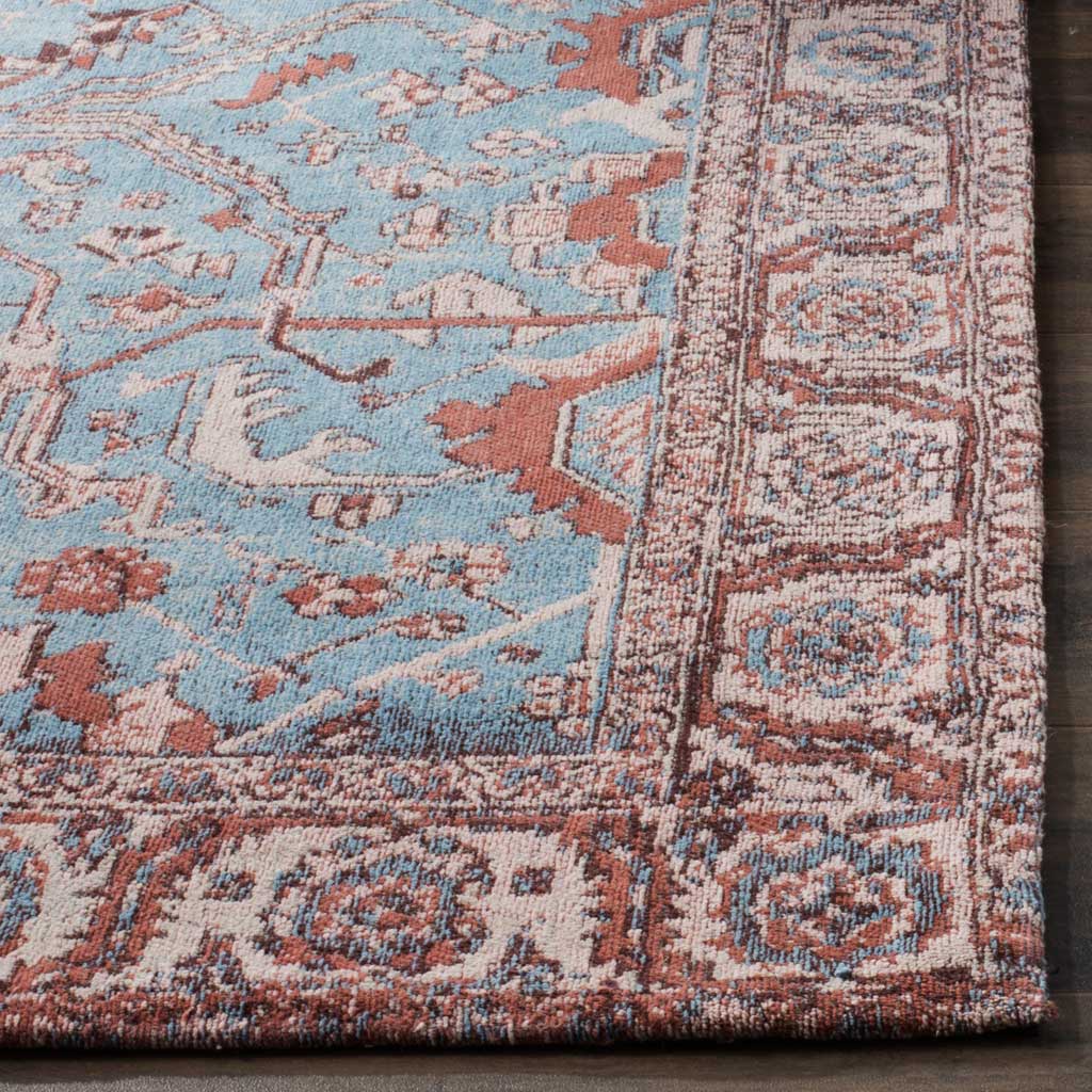 Rust-red ornamentation meets soft blue florals at the rug's neatly finished corner.