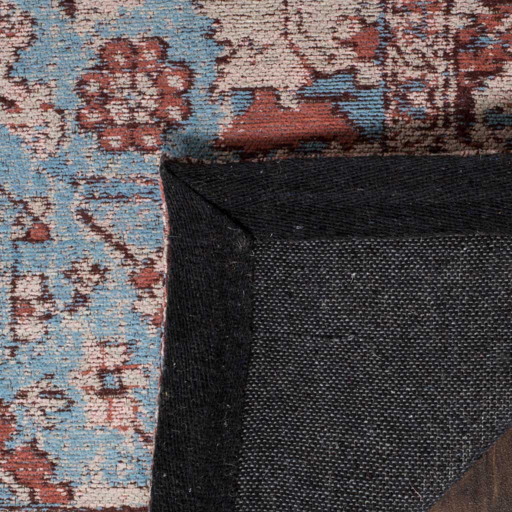 Dark woven backing and a sturdy bound edge support the blue-and-red patterned rug.