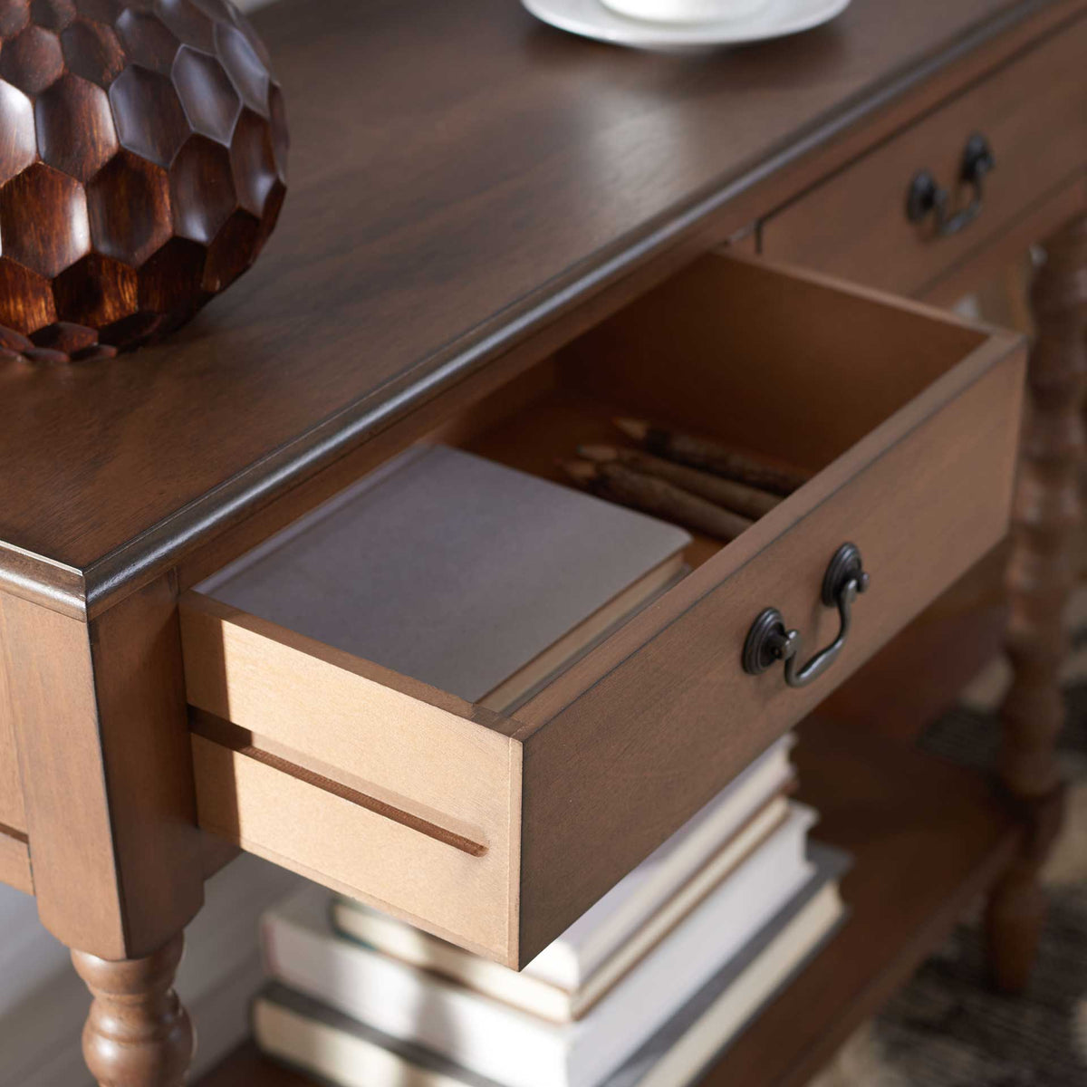 Open brown drawer offers handy storage for small items above the console's lower shelf.
