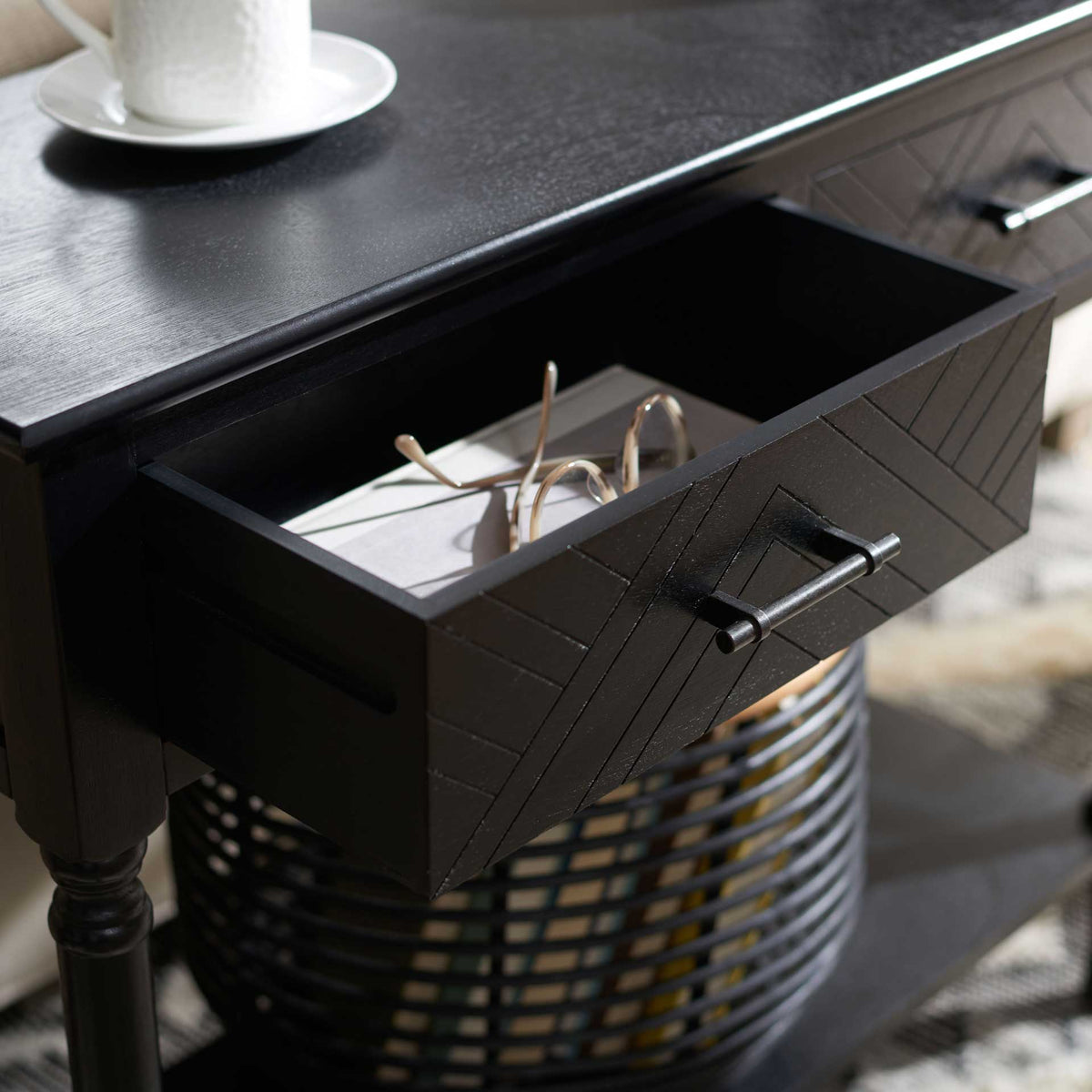 An open patterned drawer offers discreet storage above a lower shelf holding a woven basket