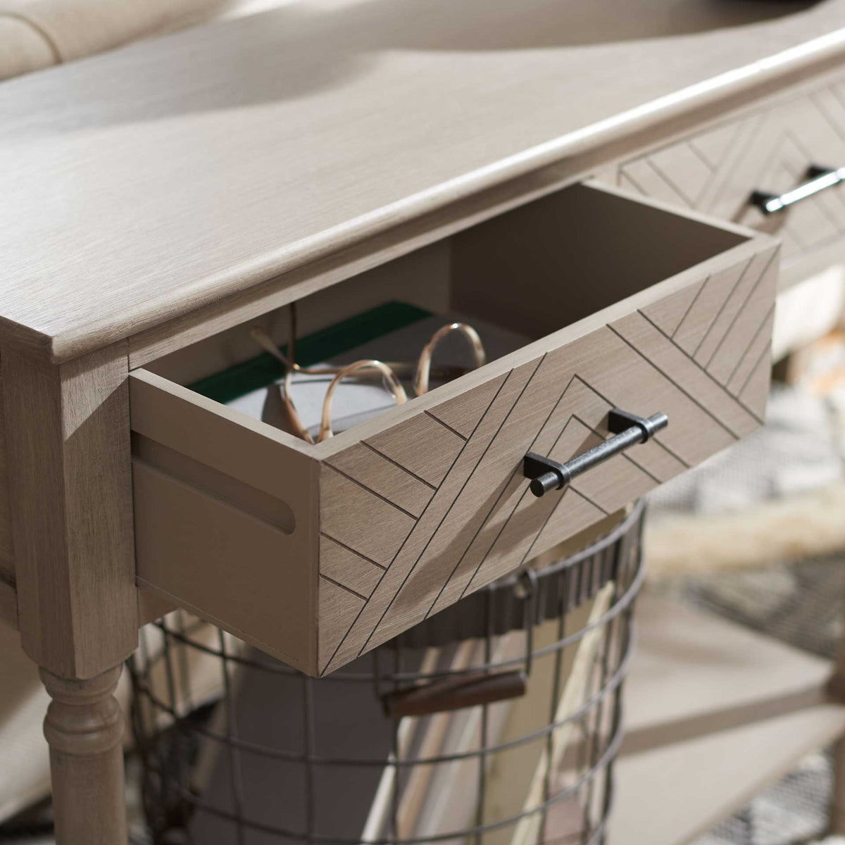An open patterned drawer holds small accessories above a shelf with a wire storage basket